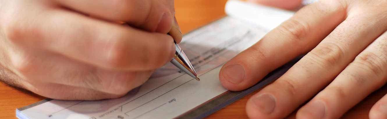 Person filling out a check for Pilot Grove Savings Bank